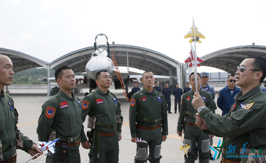 ↑舰载航空兵某部司令员戴明盟向飞行员演示空中飞行注意事项。